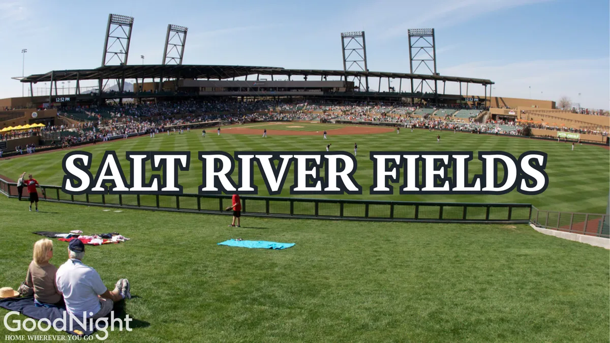 The image shows a lively baseball field filled with enthusiastic fans in the seating area and a scoreboard visible in the distance. The sense of community, excitement, and classic outdoor fun is palpable, reflecting the energy of major sports events at Salt River Fields.